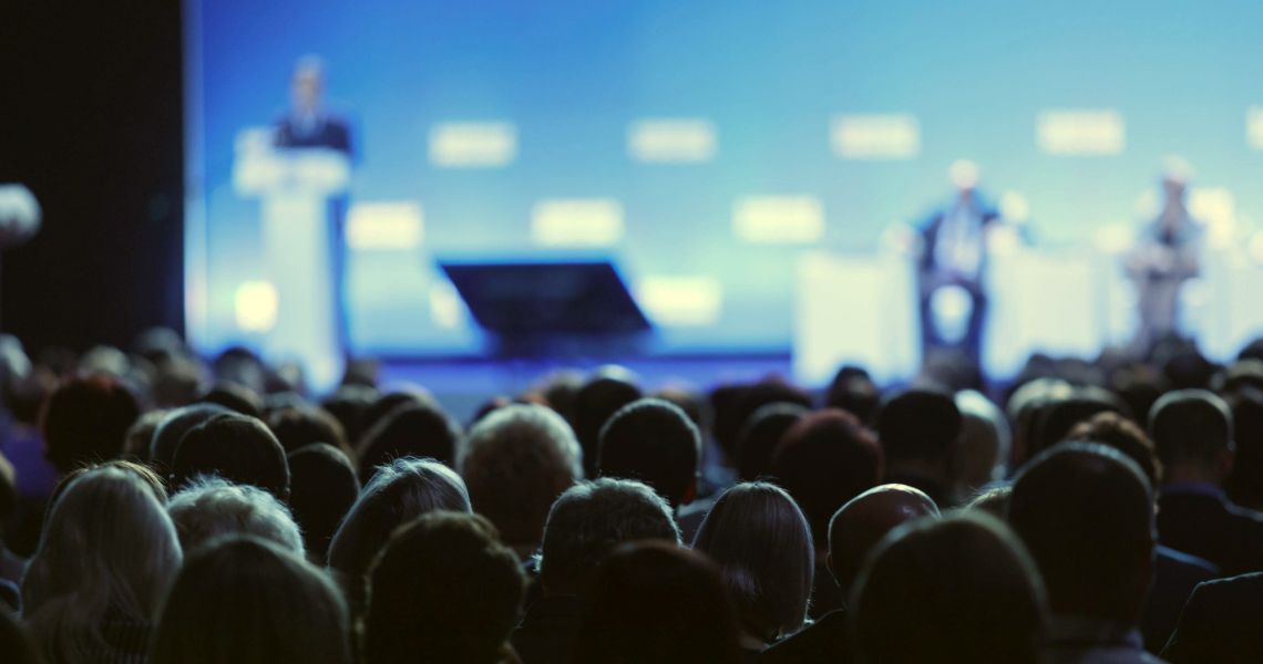 Conference Presentation on Stage with Full Audience